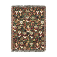 Christmas woven blanket with nutcrackers, gifts and ornaments on a deep green ground, shown flat