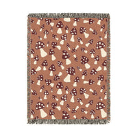 Fall woven blanket with cream and rust toadstools on a warm terracotta ground, shown flat