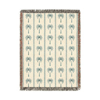 Palm Tree woven blanket in cream with teal and rust palm trees, shown flat