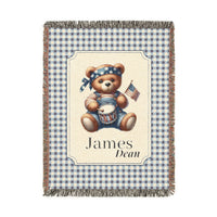 Personalized patriotic teddy bear blanket with a bear in dungarees holding a flag and drum on blue gingham, with a first and middle name woven in, shown flat
