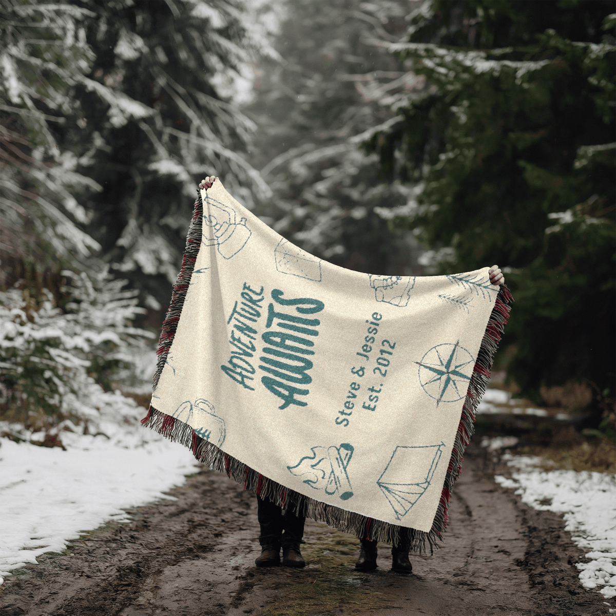 Adventure Awaits personalized woven blanket styled in a snowy forest setting
