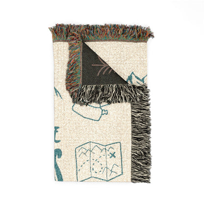 Folded corner detail of the Adventure Awaits personalized woven blanket showing the fringe edge