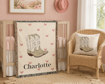 Cowgirl baby woven pillow with boots and pink hearts, styled in a nursery