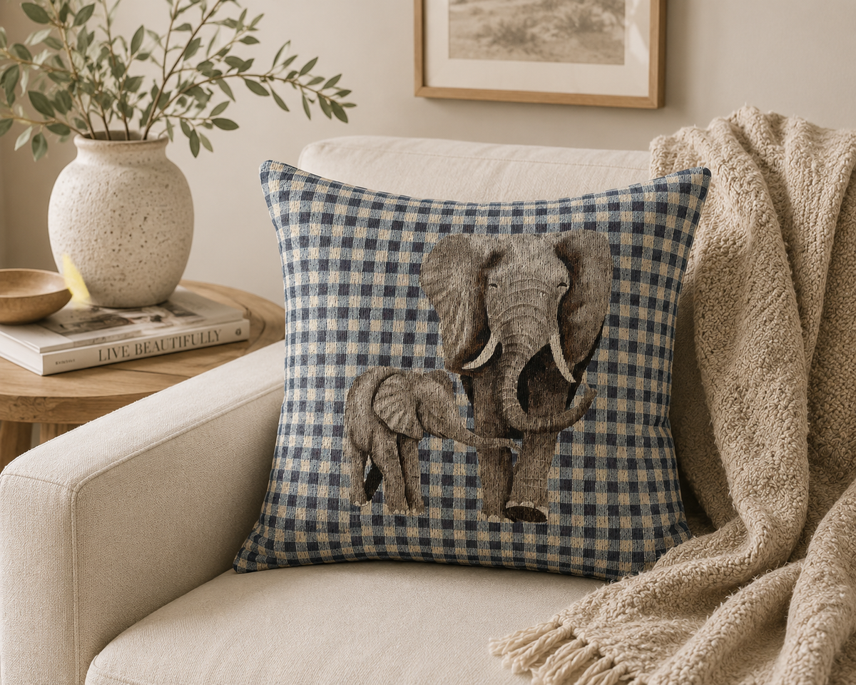 Elephant baby pillow on a cream sofa with a knitted throw