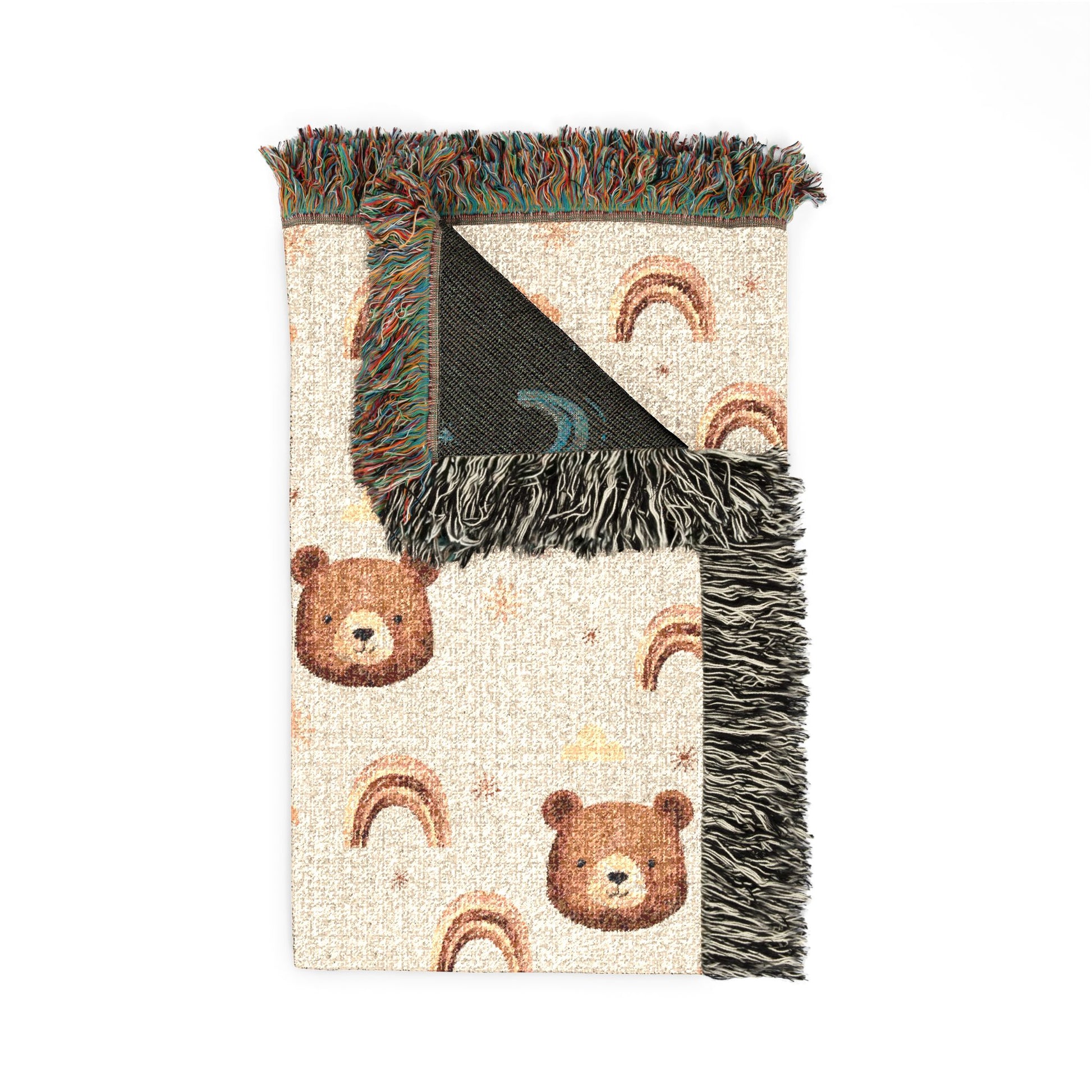 Folded bear and rainbow woven baby blanket showing the fringed edge and the dark reverse side