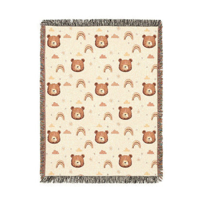 Cream woven baby blanket with brown bear faces, rainbows, clouds and stars, shown flat
