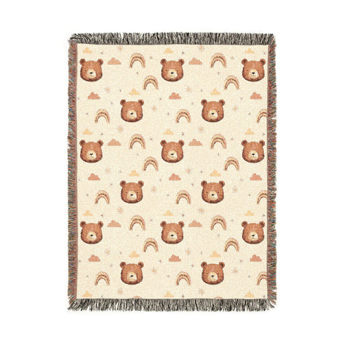 Cream woven baby blanket with brown bear faces, rainbows, clouds and stars, shown flat