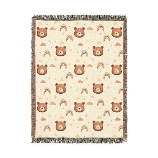Cream woven baby blanket with brown bear faces, rainbows, clouds and stars, shown flat
