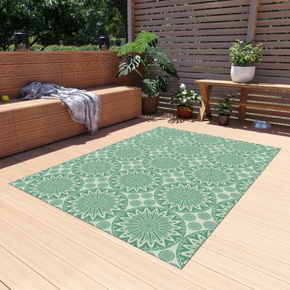 Sage green mandala outdoor rug on a wooden deck beside a built-in bench