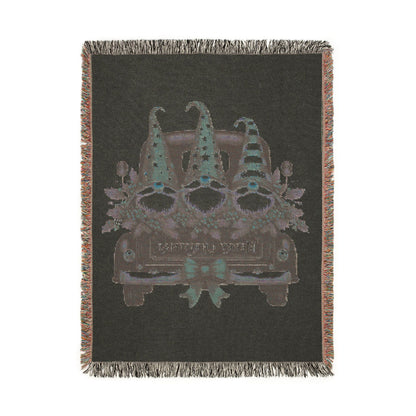 Christmas woven blanket featuring three gnomes riding in a vintage truck bed with holly, berries and a Merry Christmas message
