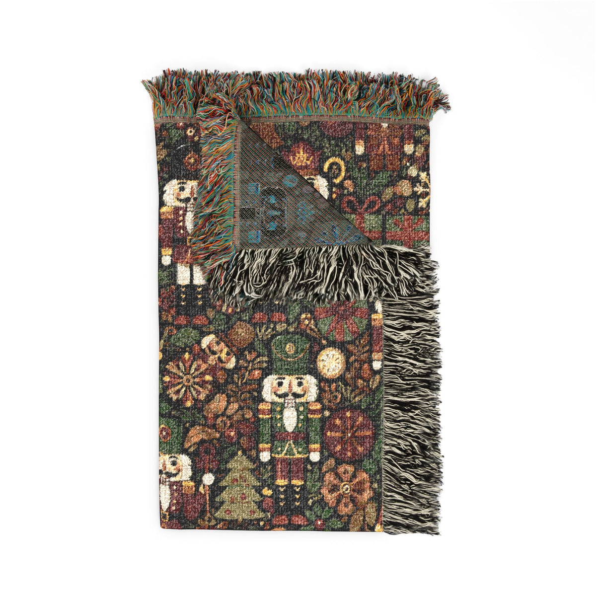 Folded Christmas nutcracker woven blanket showing the fringed edge and the grey reverse side