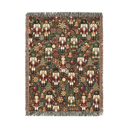 Christmas woven blanket with nutcrackers, gifts and ornaments on a deep green ground, shown flat