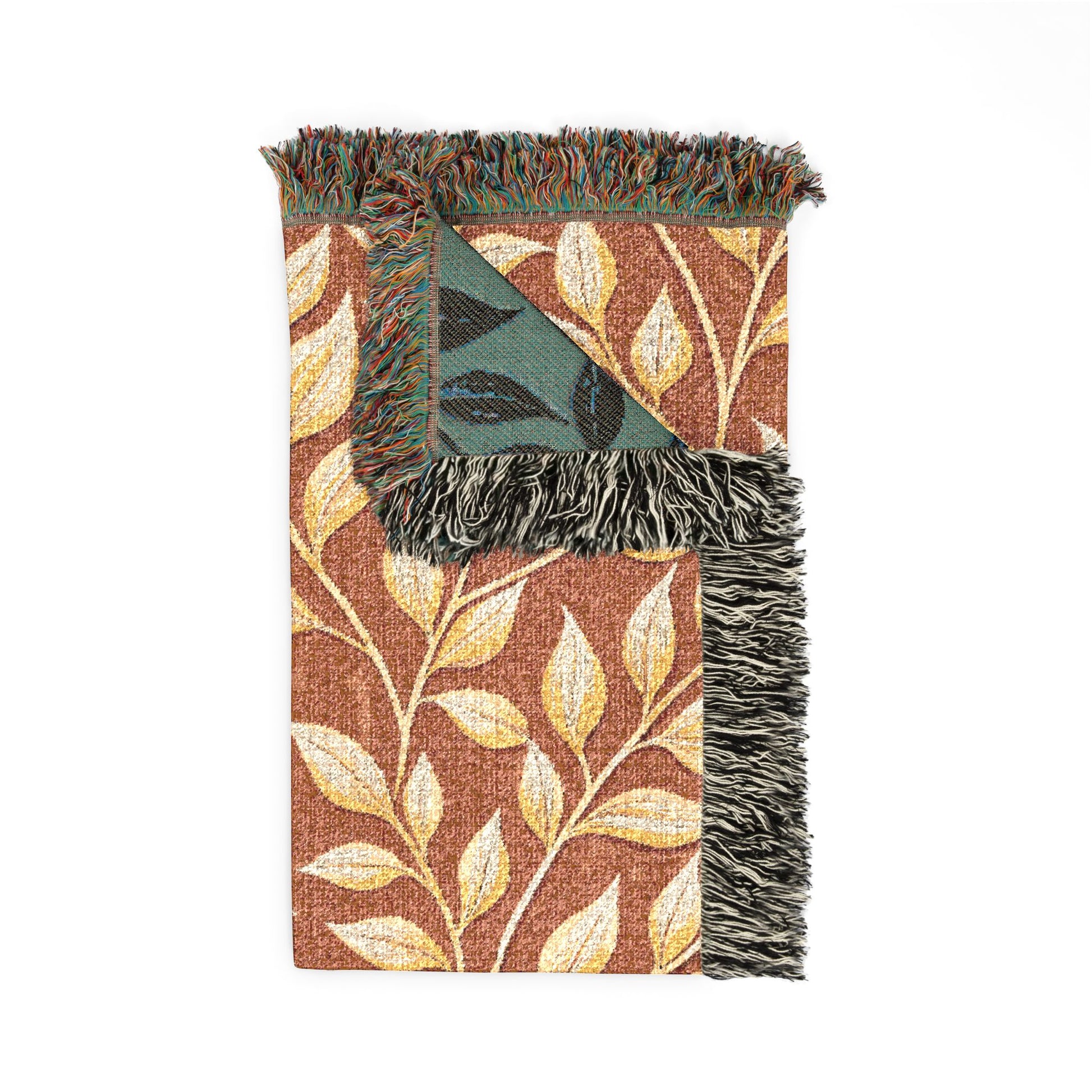 Folded terracotta woven blanket showing the sage teal reverse side and fringed edge