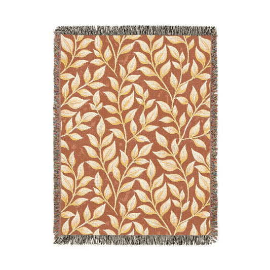 Fall woven blanket in terracotta with cream and gold leaves, shown flat
