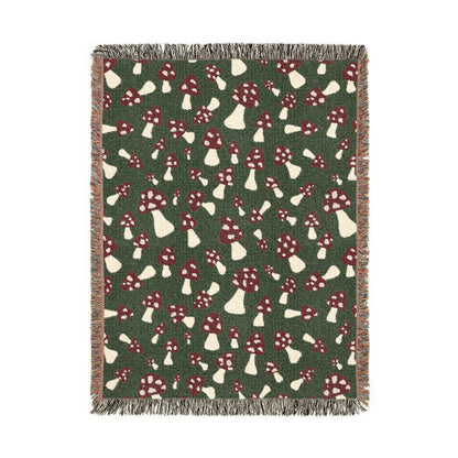 Fall woven blanket with red and cream toadstools on a deep forest green ground, shown flat