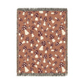 Fall woven blanket with cream and rust toadstools on a warm terracotta ground, shown flat
