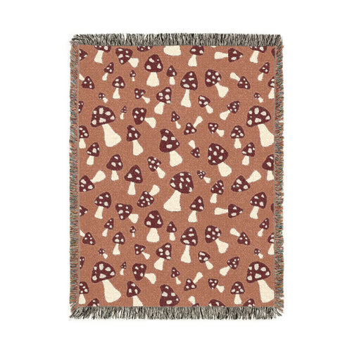 Fall woven blanket with cream and rust toadstools on a warm terracotta ground, shown flat