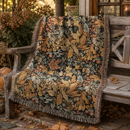 Gold and sage leaf tapestry blanket draped over an armchair by a sunlit window