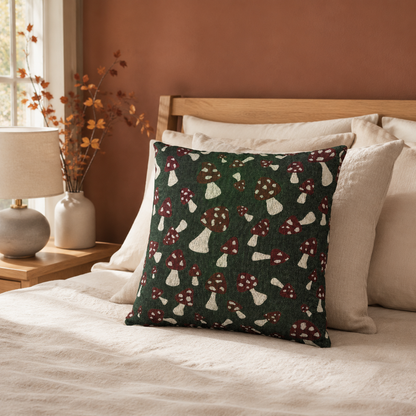 Toadstool pillow on a cream sofa against a terracotta wall with dried stems