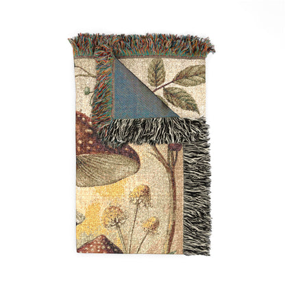 Folded forest mushroom tapestry blanket showing the fringed edge and the reverse side