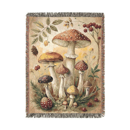 Woodland mushroom woven tapestry blanket with amber toadstools, red berries and green leaves on a cream ground, shown flat