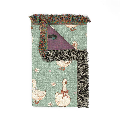 Folded goose woven blanket showing the fringed edge and the plum reverse side