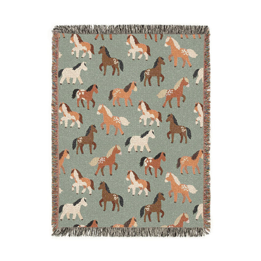 Sage green woven blanket with chestnut, rust and cream horses walking across it, shown flat