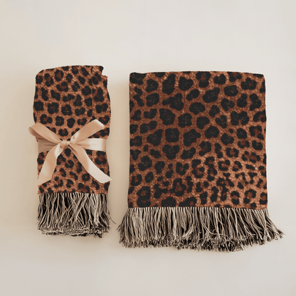 Leopard woven blanket over an outdoor chair with lanterns at dusk