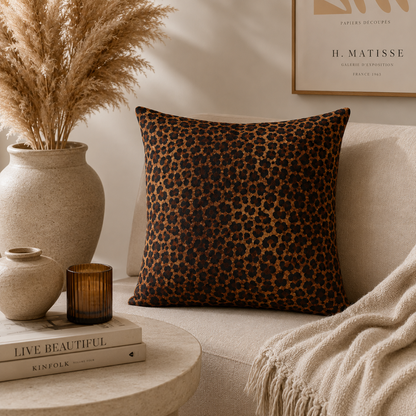 Leopard woven pillow on a cream sofa with candles and pampas grass