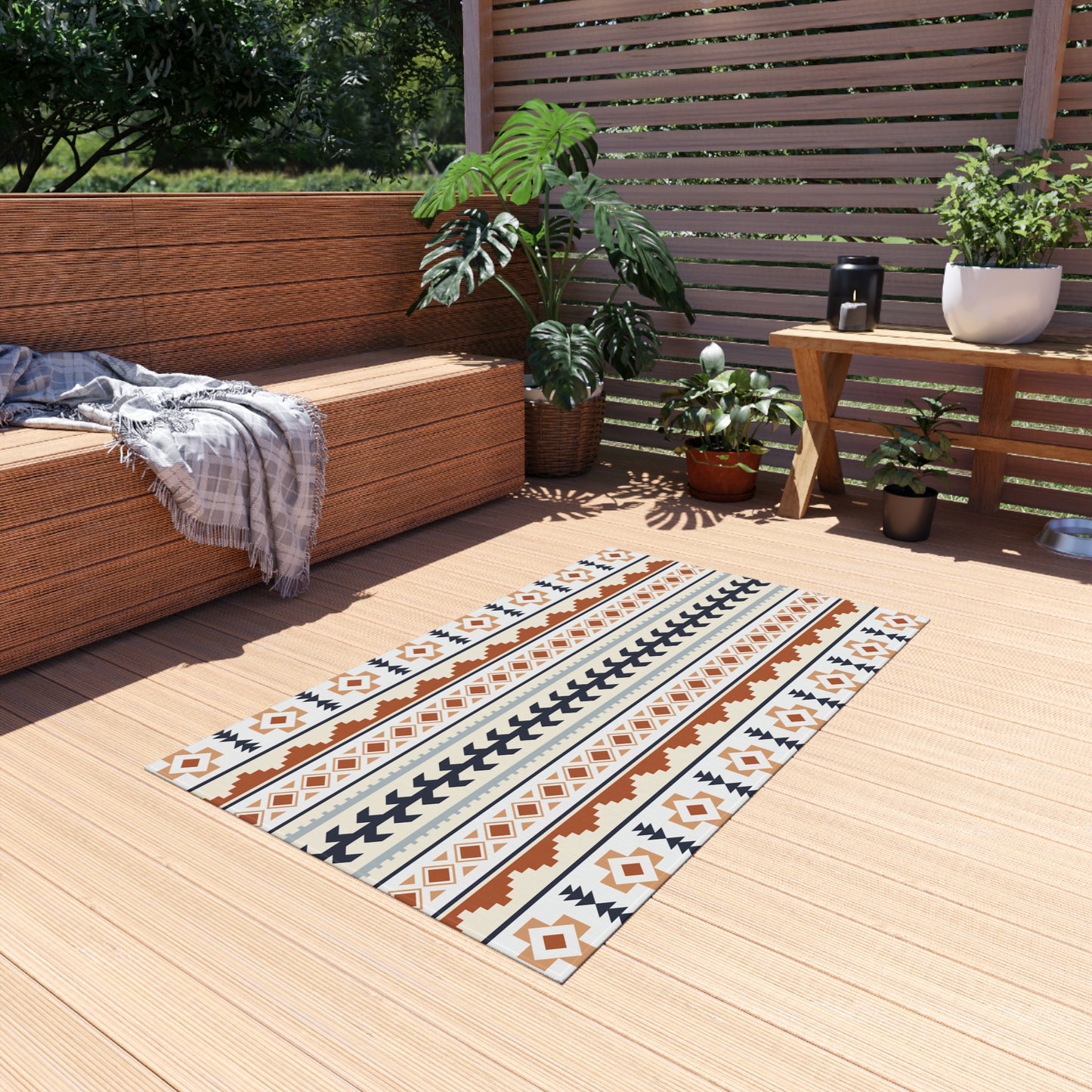 Southwestern outdoor rug on a wooden deck beside a bench and potted plants
