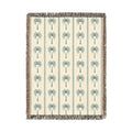Palm Tree woven blanket in cream with teal and rust palm trees, shown flat