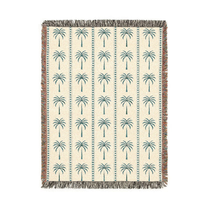 Palm Tree woven blanket in cream with teal and rust palm trees, shown flat