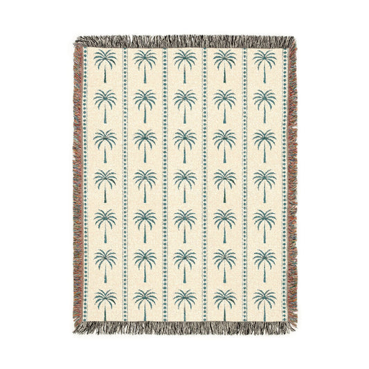 Palm Tree woven blanket in cream with teal and rust palm trees, shown flat