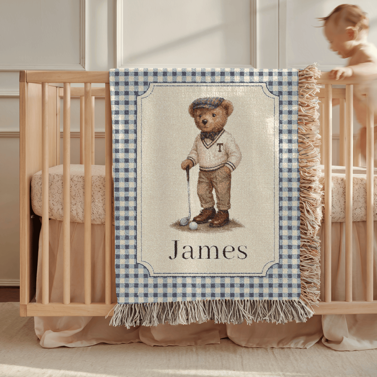 Personalized bear golf baby blanket draped over a crib rail in a nursery