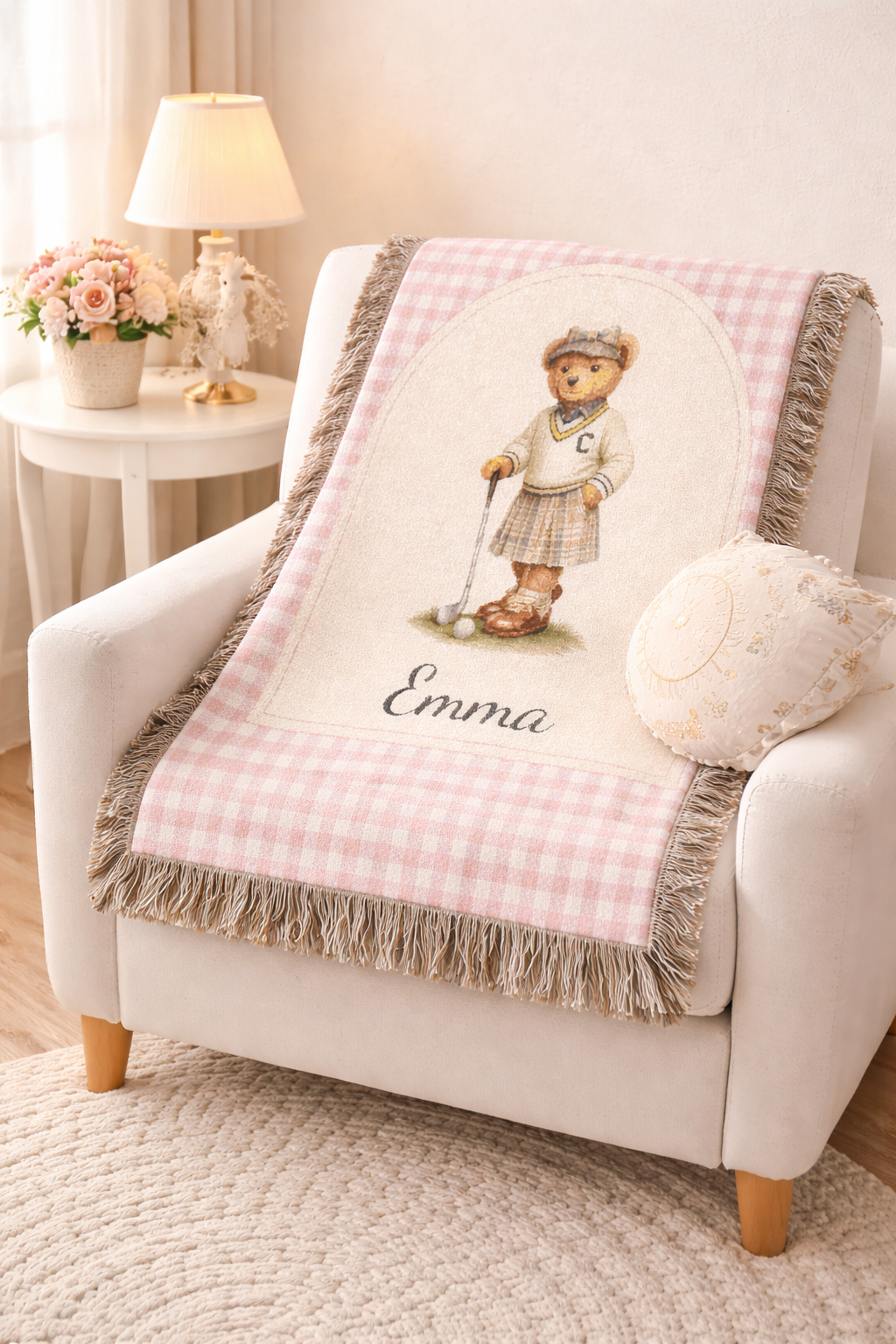 Personalized bear golf baby blanket over a nursery armchair beside a lamp