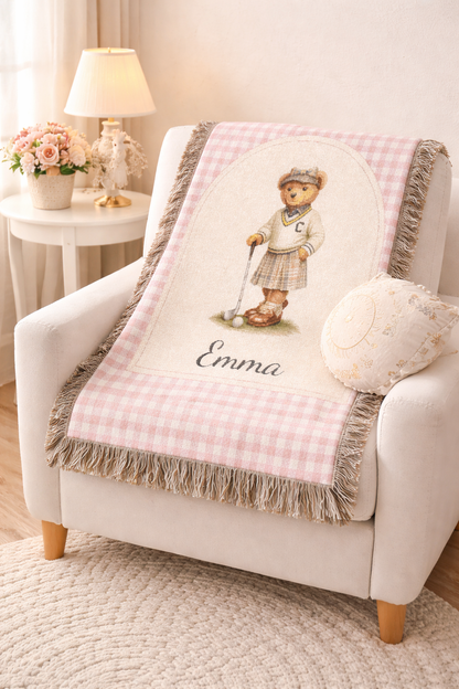Personalized bear golf baby blanket over a nursery armchair beside a lamp