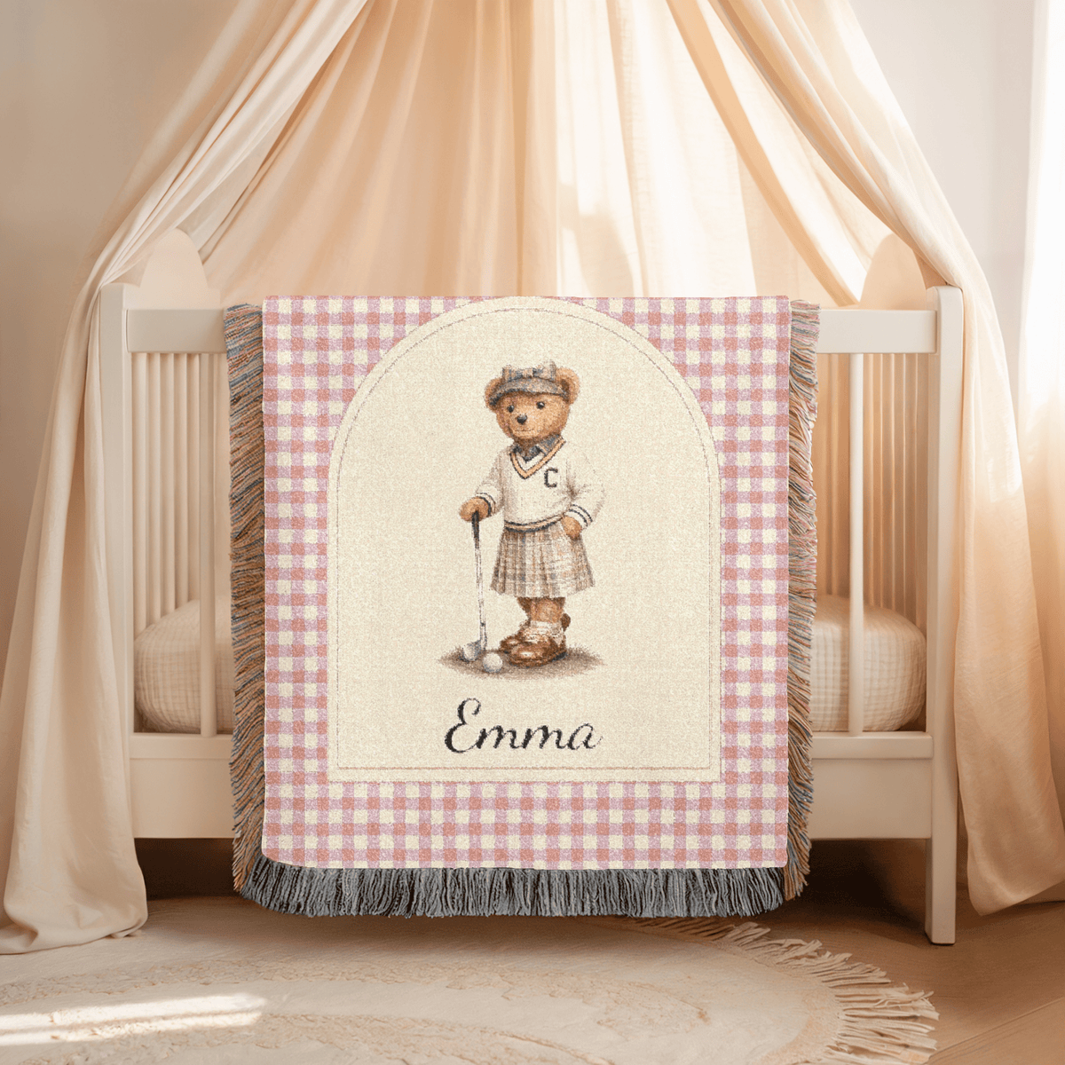 Personalized bear golf baby blanket draped over a crib in a soft pink nursery