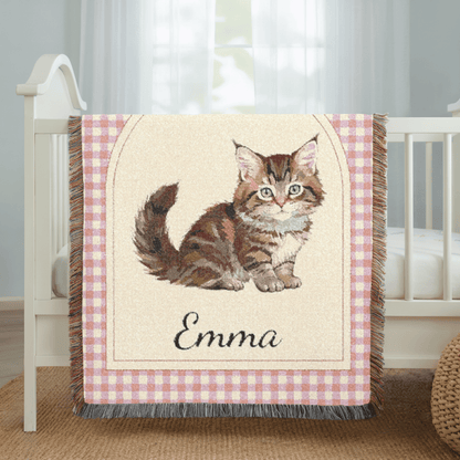 Personalized cat baby blanket draped over a crib rail in a bright nursery