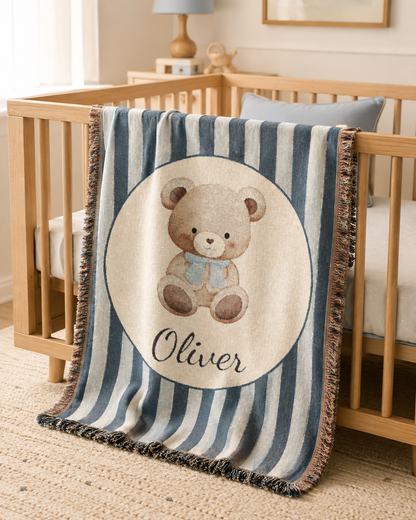Personalized navy stripe teddy bear blanket over the rail of a wooden crib
