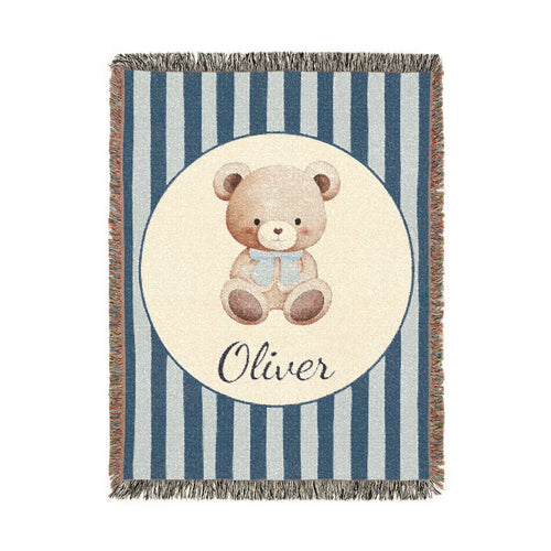 Personalized woven baby blanket with a watercolour teddy bear in a cream circle on a navy and pale blue stripe, with a name woven in, shown flat