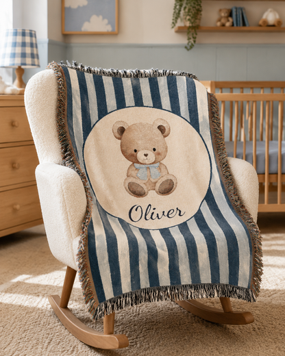 Personalized navy stripe teddy bear blanket over a rocking chair beside a crib