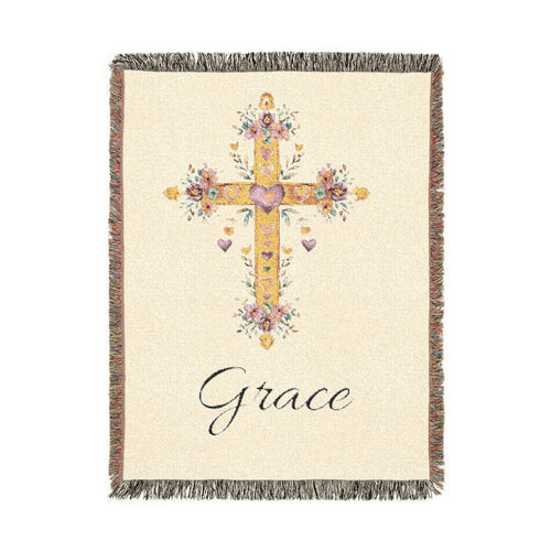 Personalized baptism blanket with a gold floral cross on cream and a name woven in beneath it, shown flat