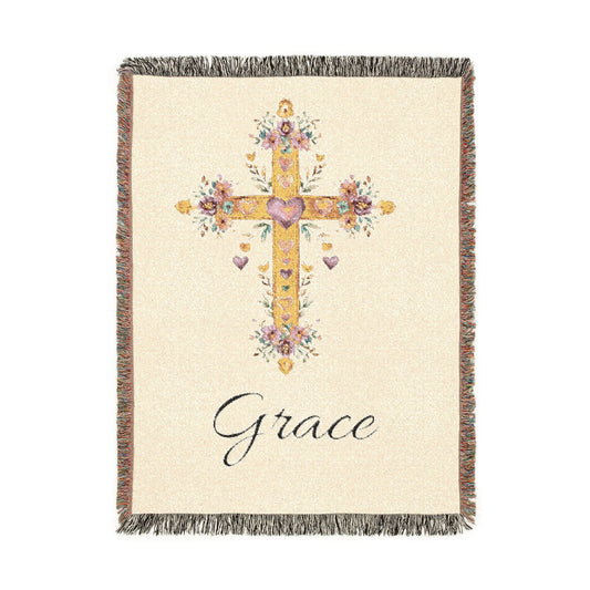 Personalized baptism blanket with a gold floral cross on cream and a name woven in beneath it, shown flat