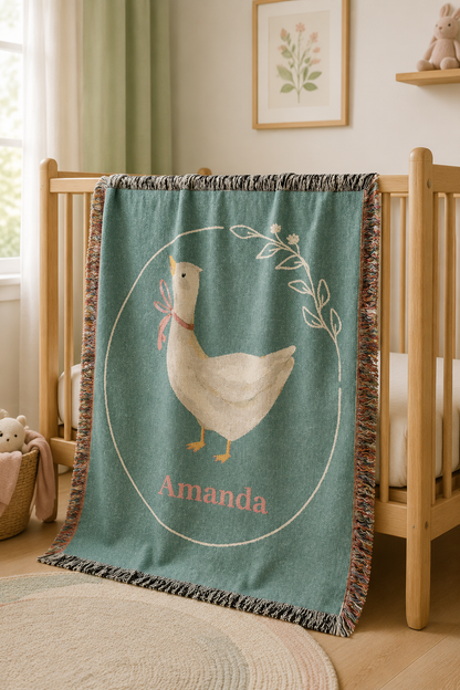 Personalized goose baby blanket draped over the rail of a wooden crib