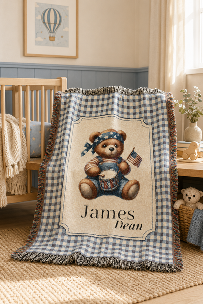 Personalized patriotic teddy bear blanket over the rail of a crib in a nursery