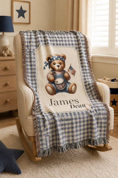 Personalized patriotic teddy bear blanket over a rocking chair in a bright nursery