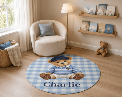 Teddy bear round nursery rug in front of a cream armchair with nursery shelves behind