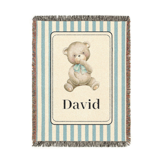 Personalized woven baby blanket with a watercolour teddy bear in a cream panel on a blue and cream stripe, with a name woven in, shown flat
