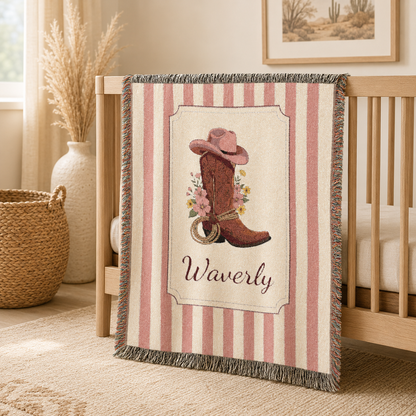 Personalized cowgirl boot baby blanket draped over the rail of a white crib