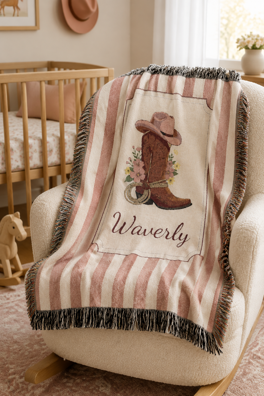 Personalized cowgirl boot baby blanket over a cream nursery chair beside a crib